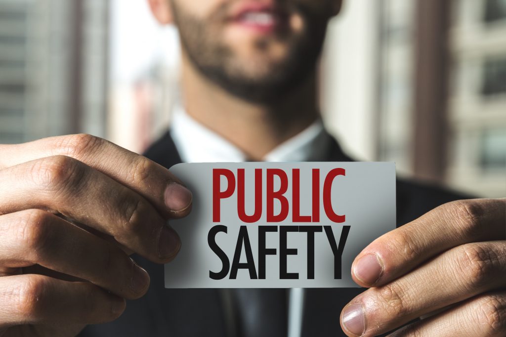 Man holding up a small sign that says "Public Safety"